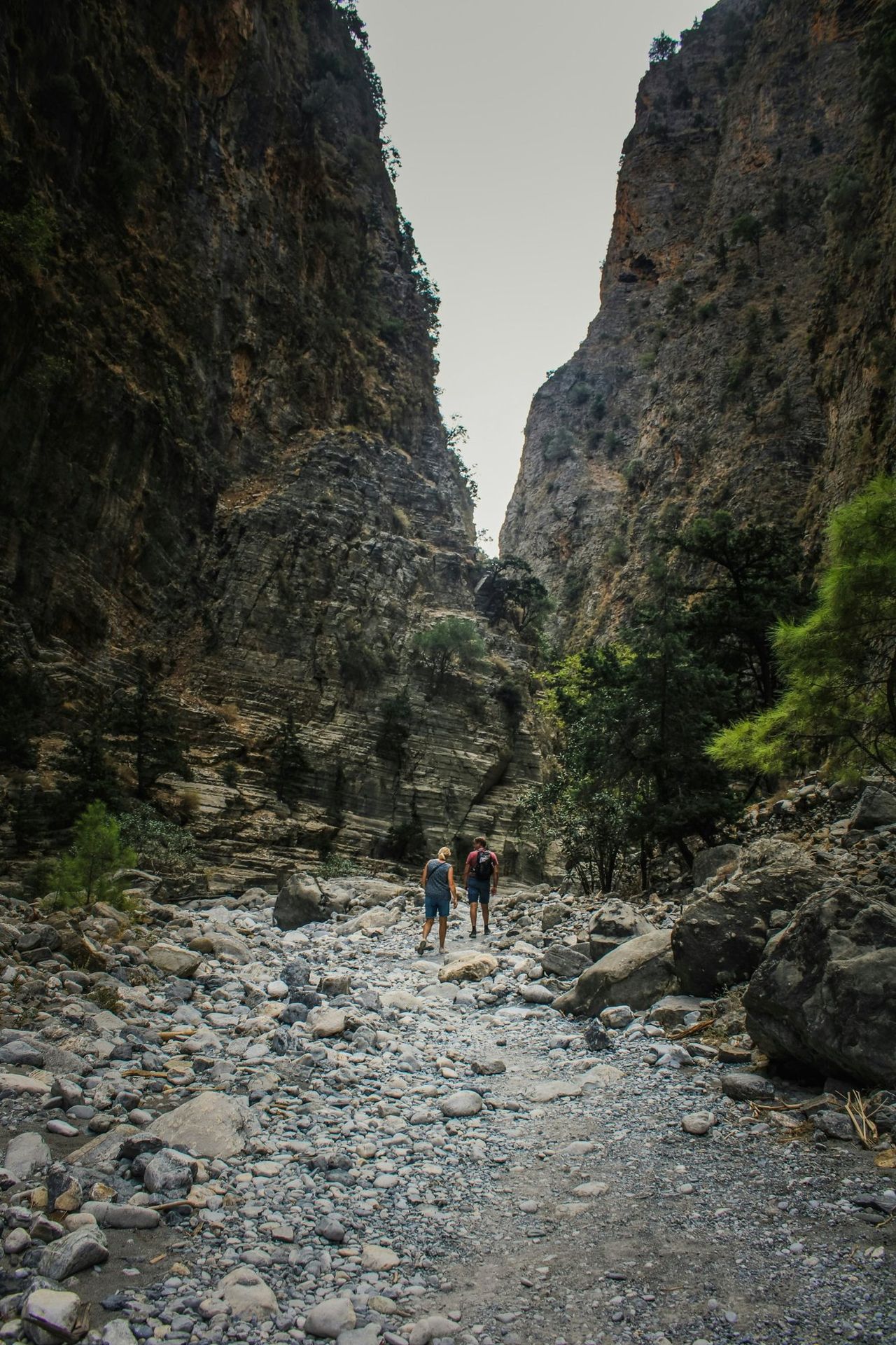 Two walkers between the high rock walls of the Samaria gorge