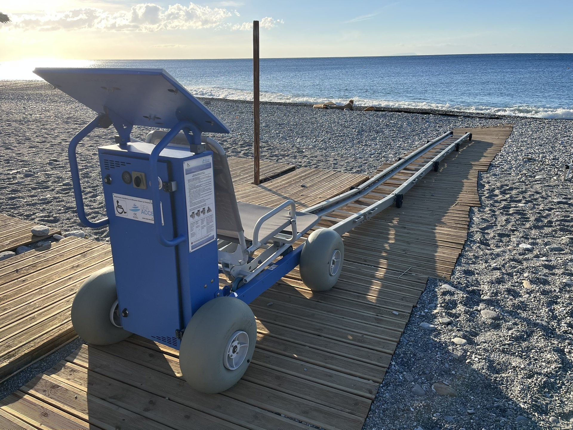 The Sea Access seat on its rails and the wooden walkway on Sougia beach