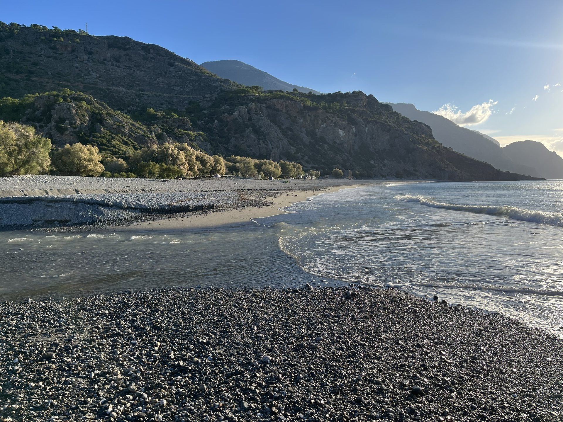 The river spreading over the sand and meeting the waves on an October morning, the mountains behind