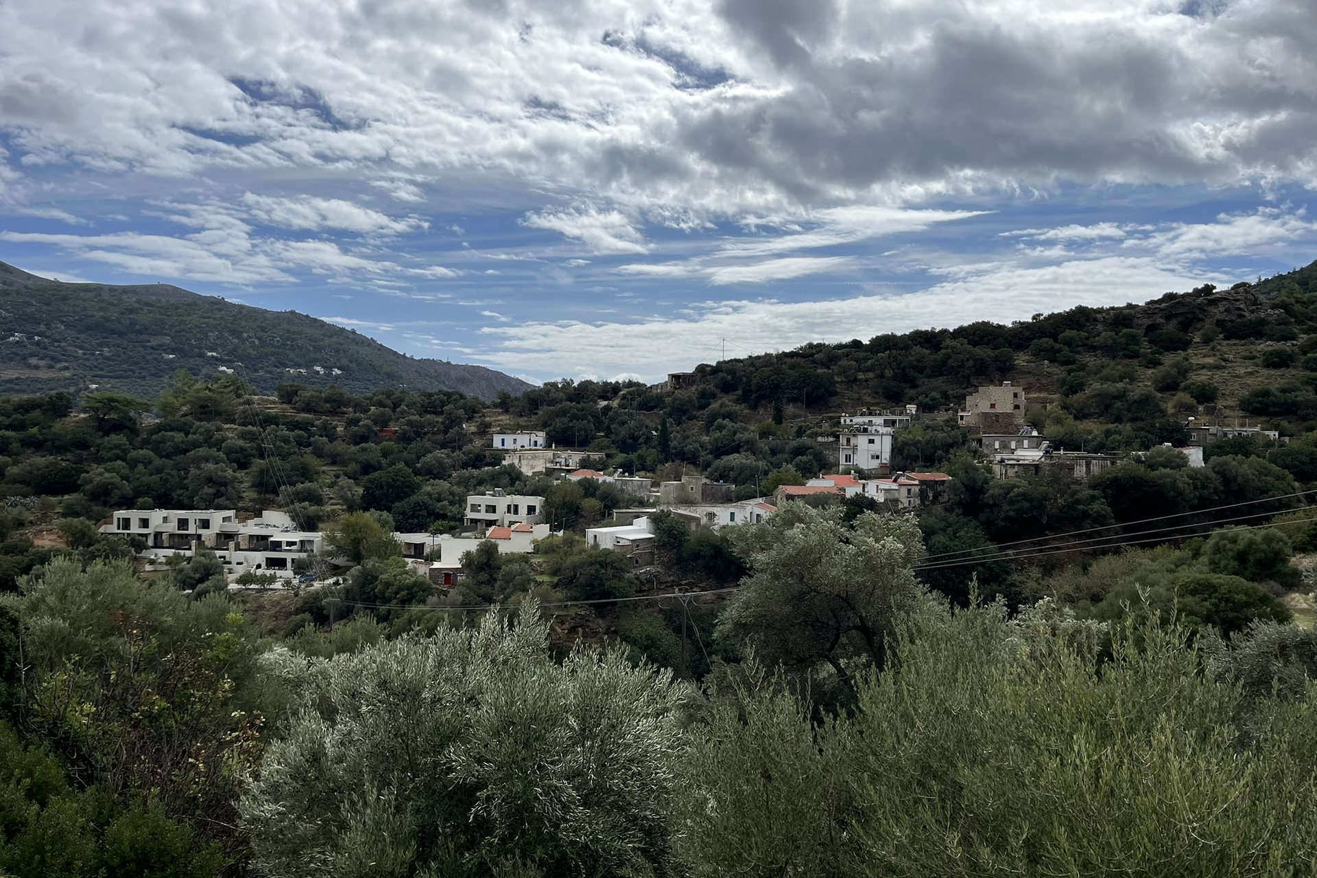 Moni from above, white houses scattered among olive groves below the mountains