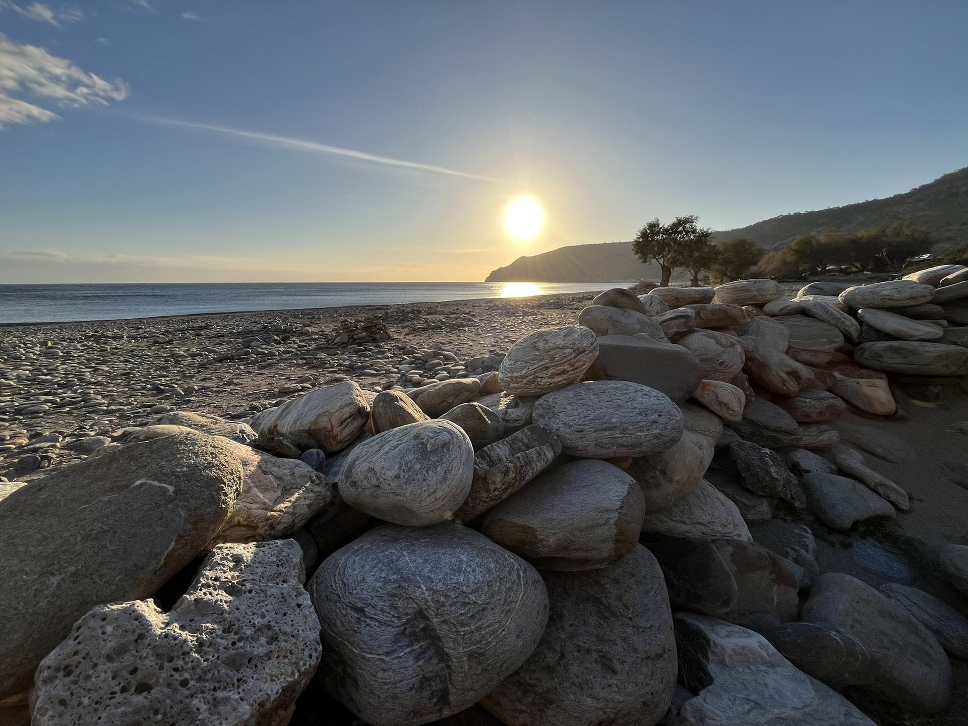 Sunset over the stone walls of the beach
