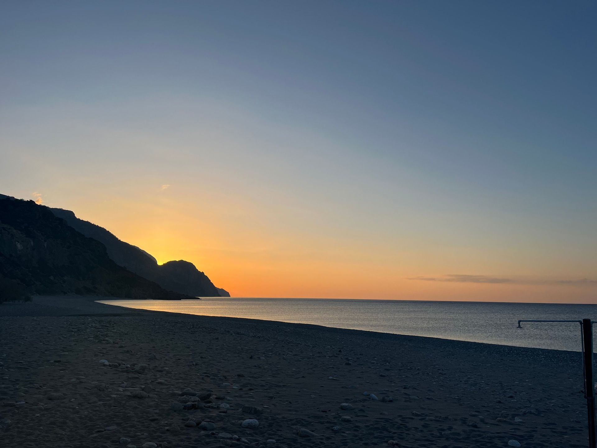 First light behind the cape, the sea completely still in front of Sougia